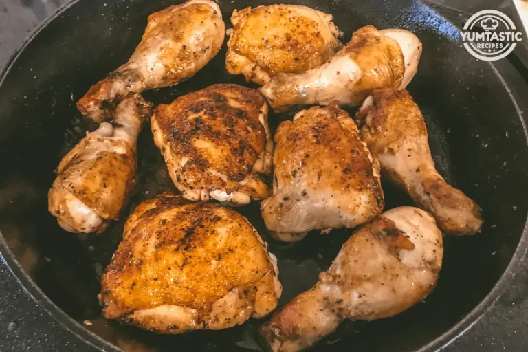 Several pieces of chicken fricassee browning in a black cast-iron skillet.